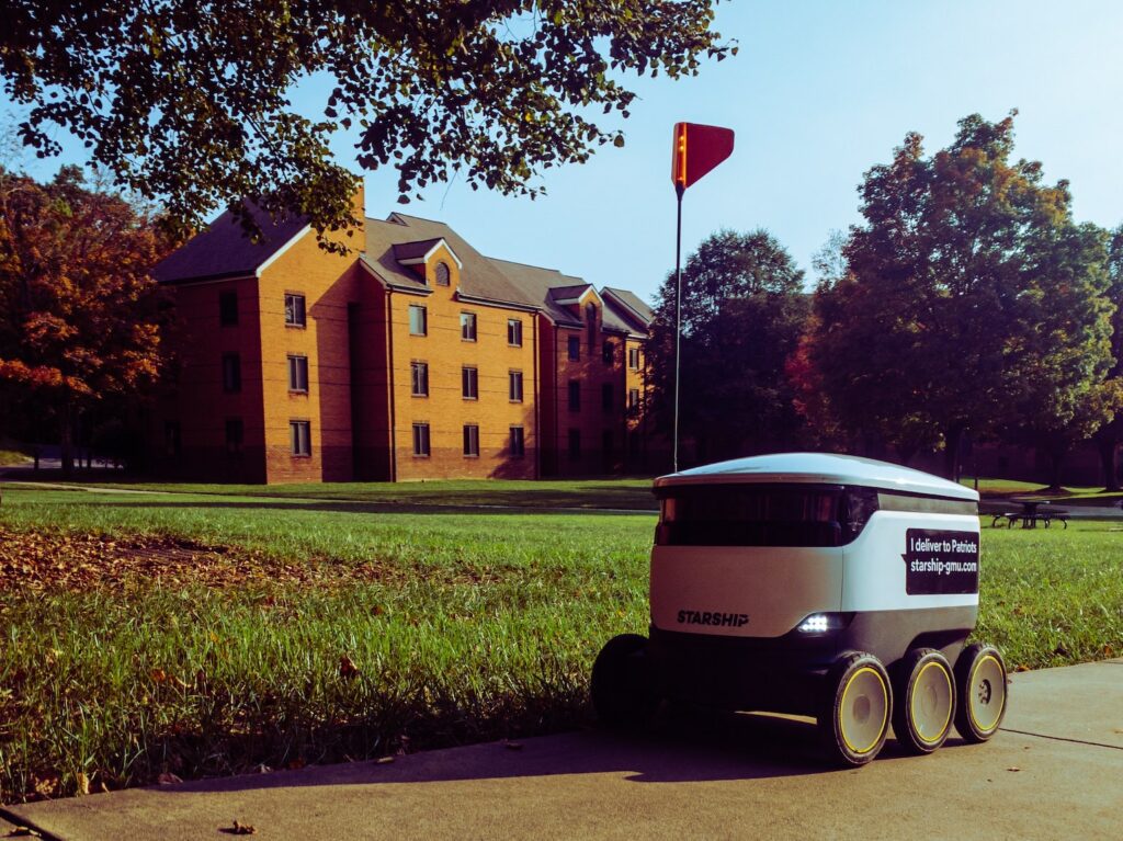 Delivery robot parked beside lawn